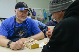 A major program of the Knights of Columbus Westminster Council is aiding the local Cold Weather Shelter assisting homeless clients. Knights of Columbus member John Bryan lends an ear and support to a shelter client as he eats his evening meal.